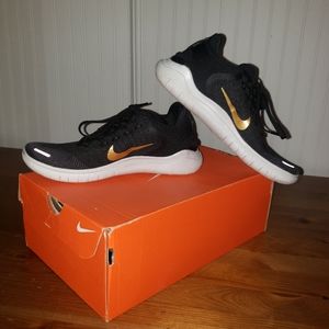 Nike womens black sneaker with gold swoosh